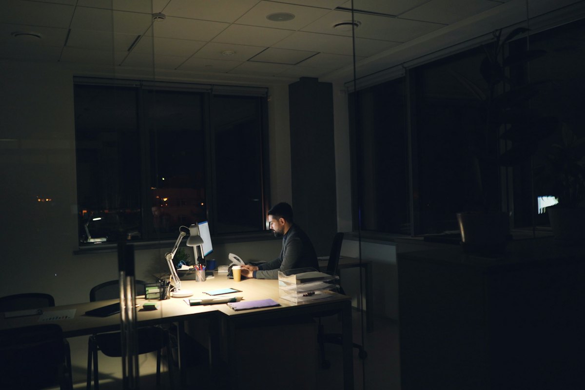 A man working alone late in a dark office