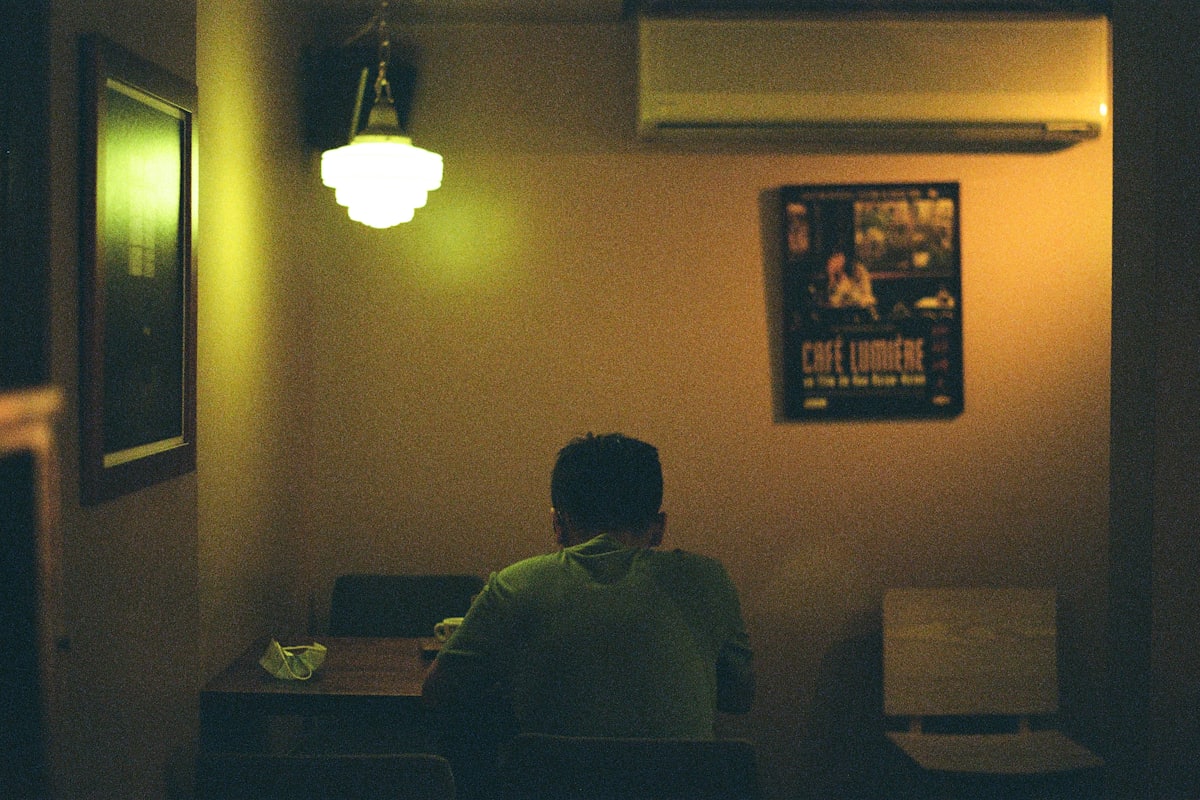 Two people sitting apart in a kitchen at night